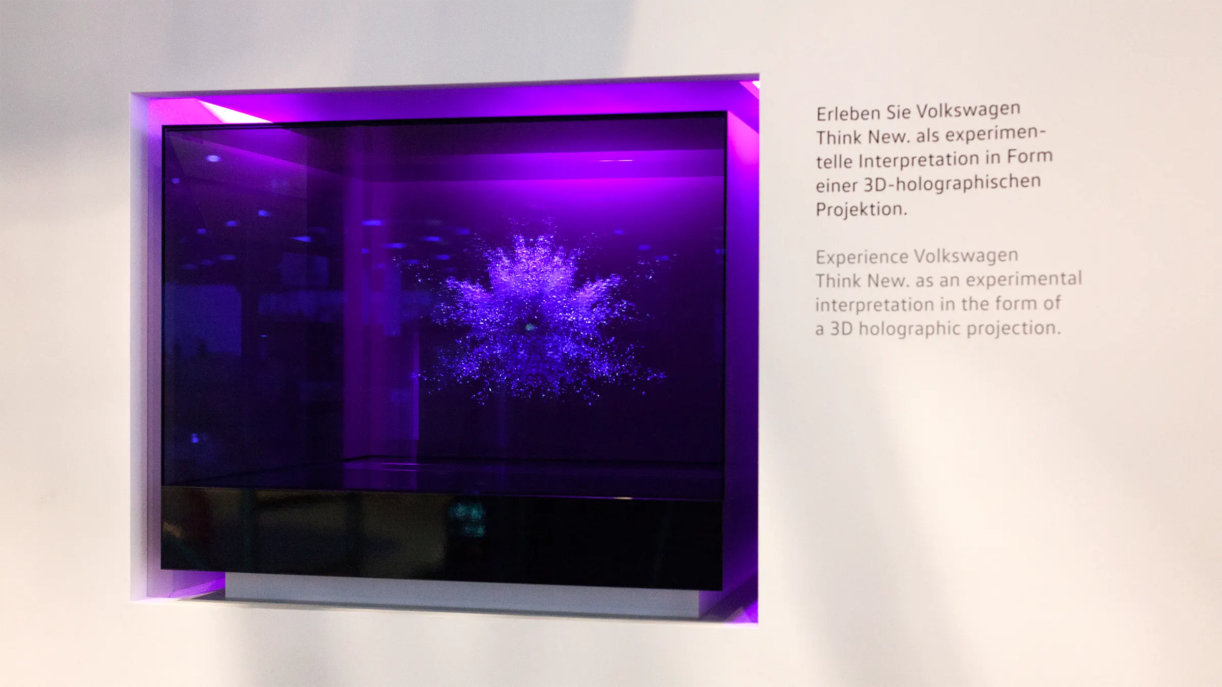 A purple explosion inside a glass cube which is integrated into a wall